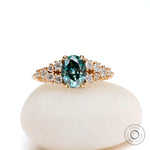 Oval blue green moissanite cluster ring in yellow gold