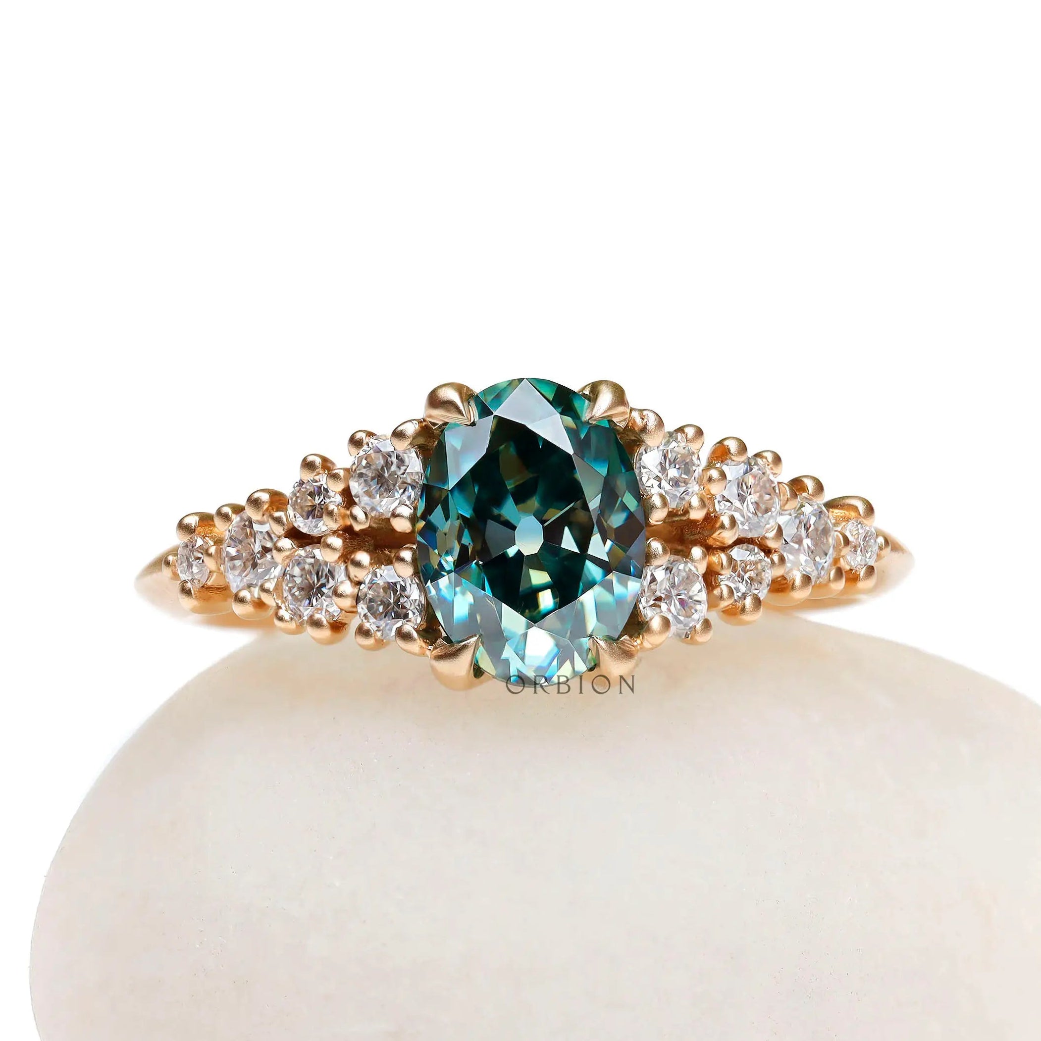 Oval blue green moissanite cluster ring in yellow gold