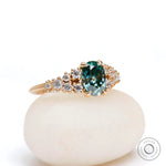 Oval moissanite ring with graduated round cluster accents