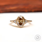 Front view of oval champagne moissanite three stone ring
