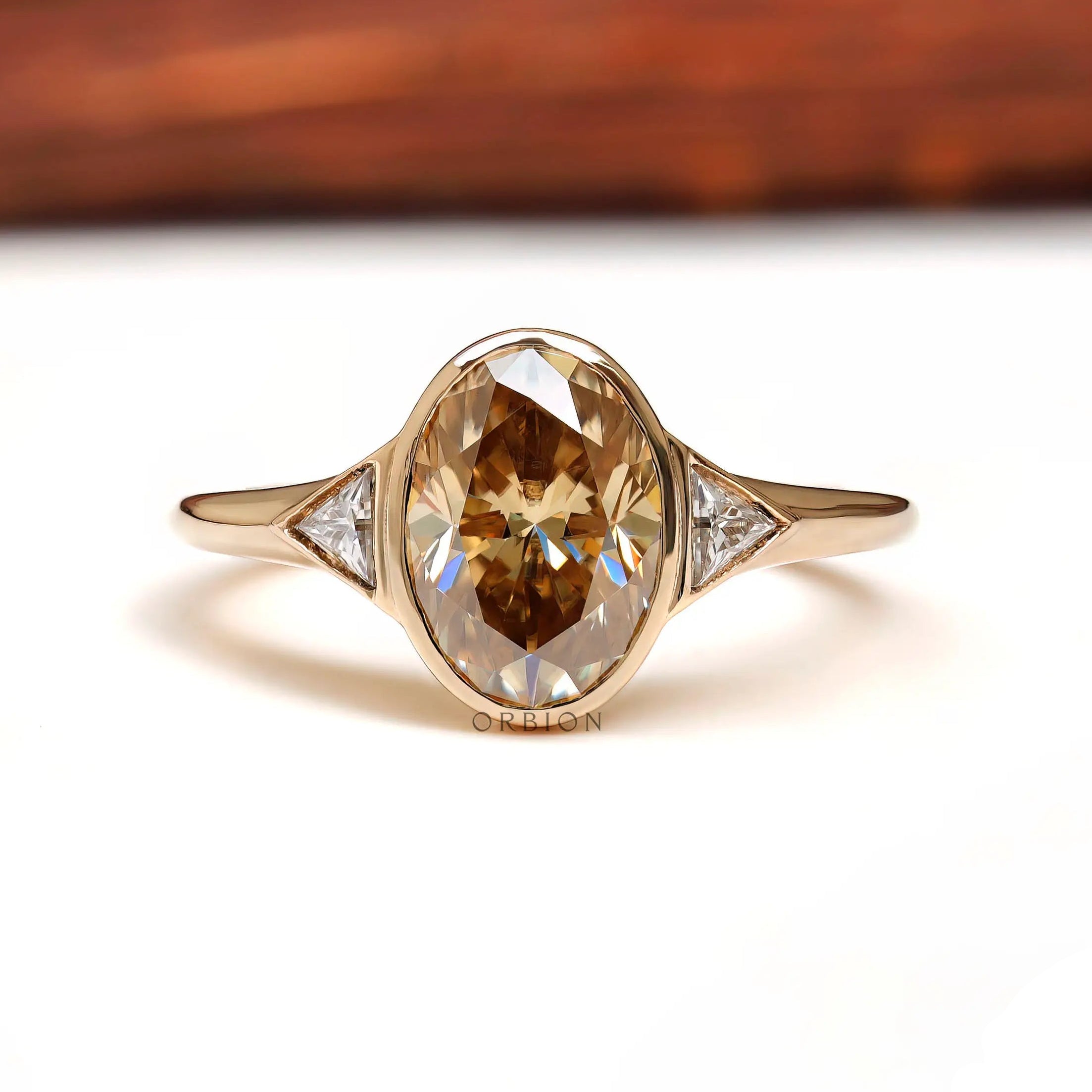 Front view of oval champagne moissanite three stone ring