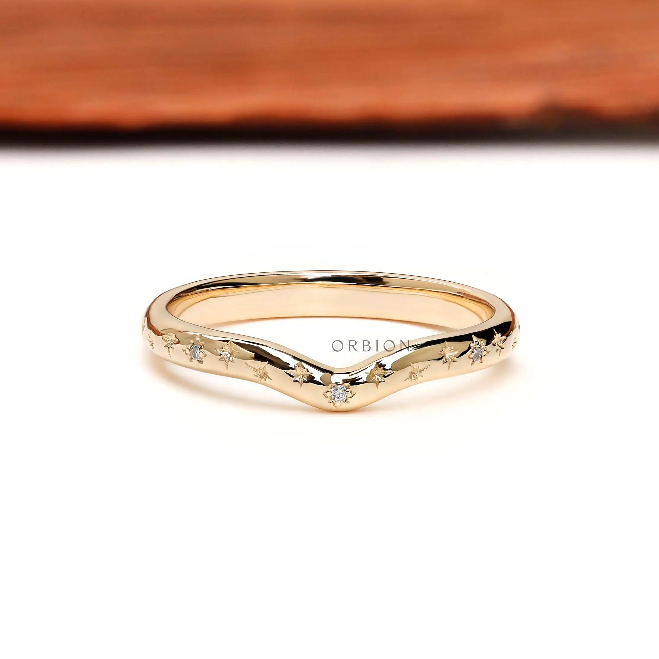 Front view of starburst curved stacking wedding band with delicate round accents.