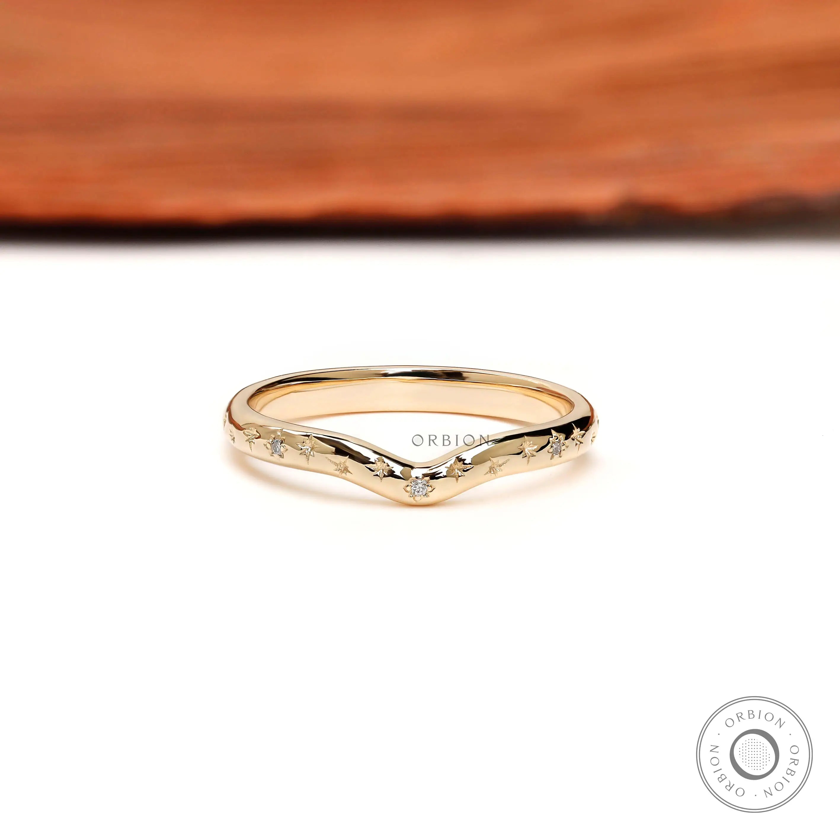 Front view of starburst curved stacking wedding band with delicate round accents.