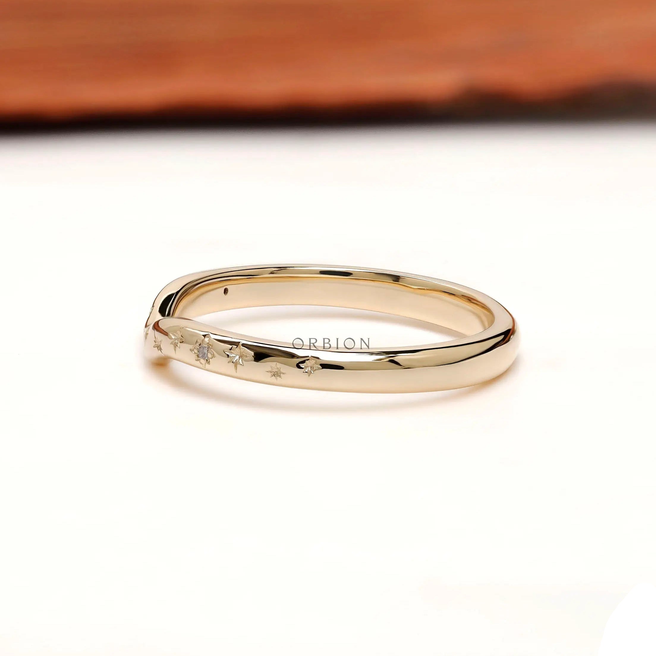 Side profile of curved stacking band showing starburst-inspired accents along the curve.