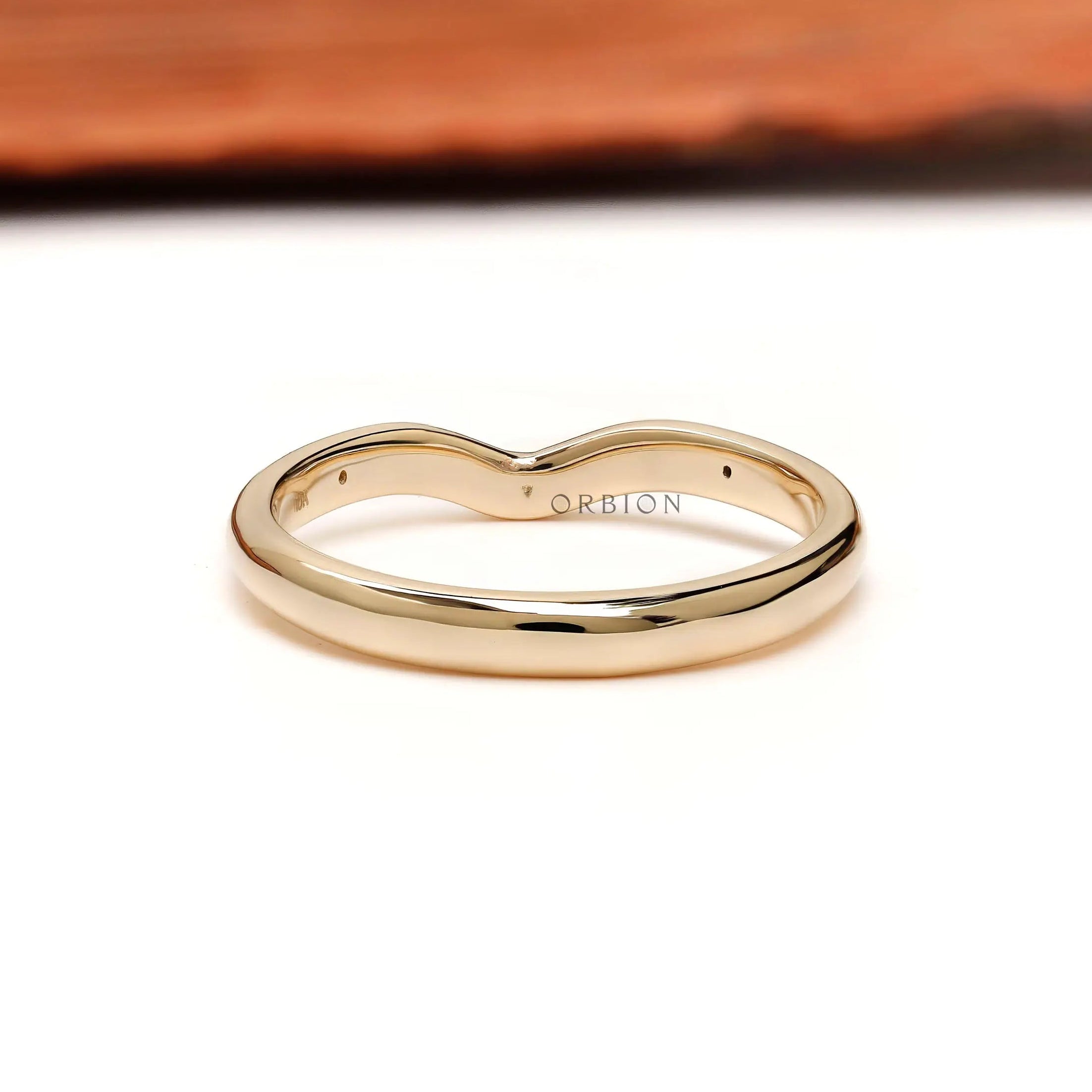 Back view of curved nesting wedding band with starburst details on both shoulders.