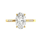 Top view oval moissanite engagement ring in yellow gold on white background