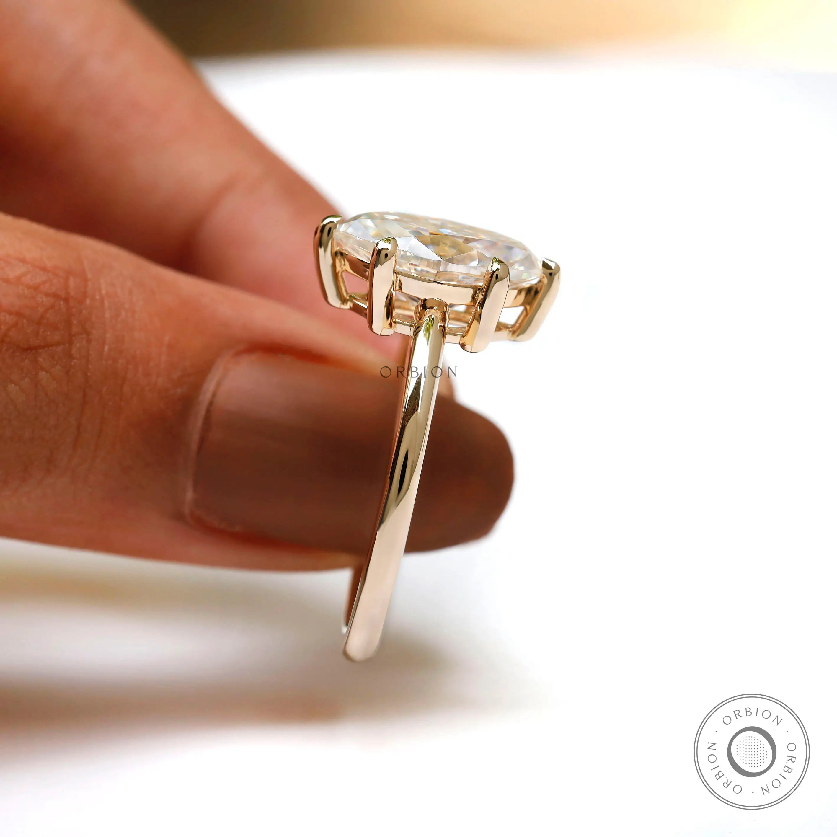 Handheld side view of marquise solitaire showing prong height and basket.