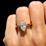 On-finger closeup top view marquise moissanite solitaire in yellow gold.