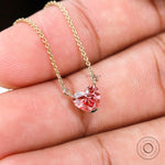 Macro front view of pink heart diamond loop pendant on gold chain