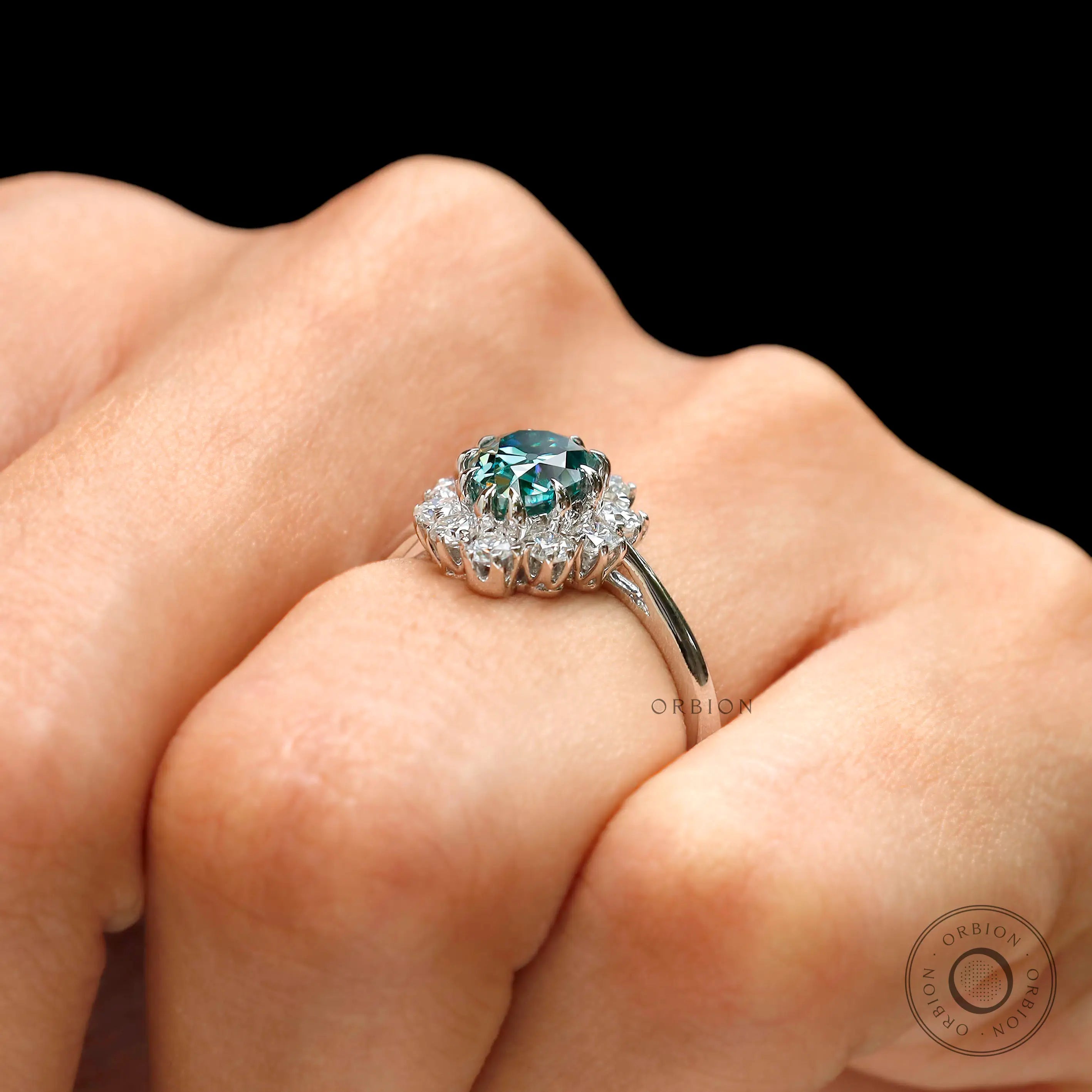 Blue green moissanite ring worn on hand