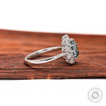 White gold pear blue green halo engagement ring angled view