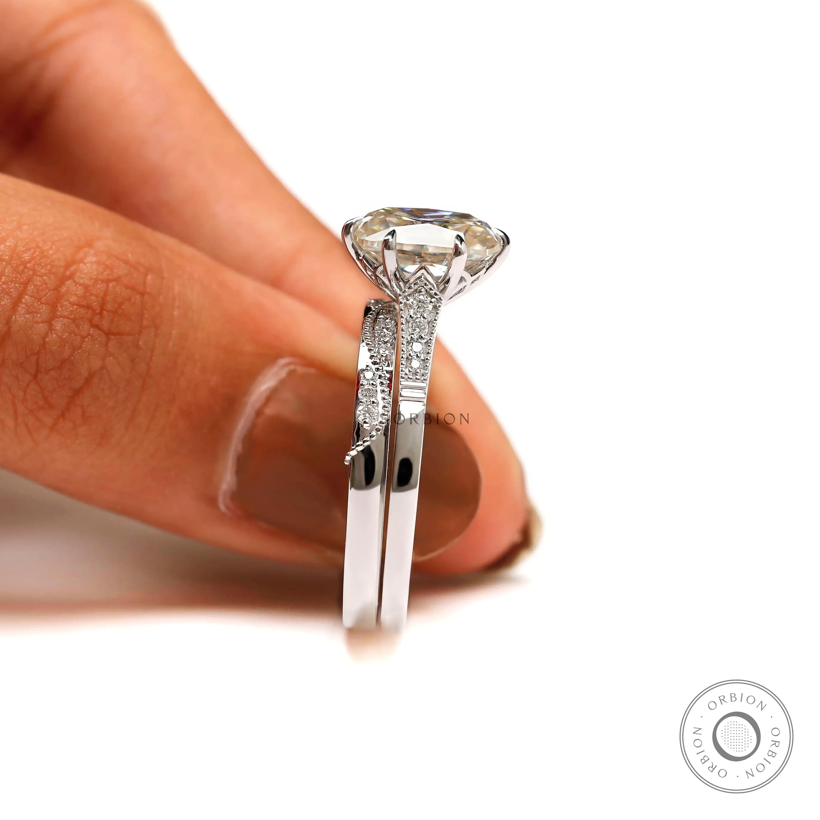 Side profile of the elongated cushion Moissanite engagement ring on a finger, showcasing the brilliant-cut side stones