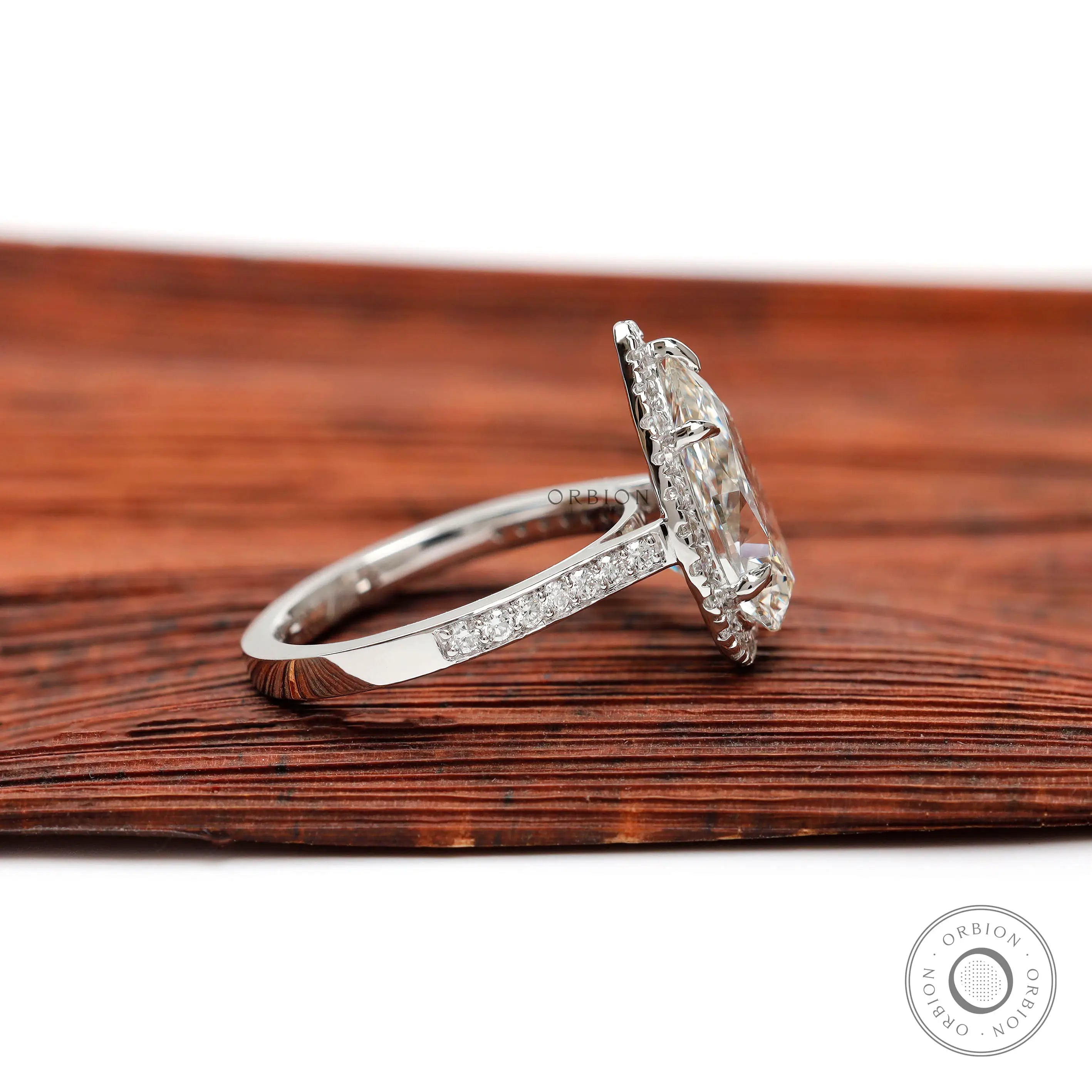 Side profile of pear shaped diamond halo ring with pavé band