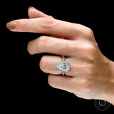 Pear cut diamond halo engagement ring worn on hand
