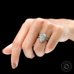 Angled lifestyle view of pear halo diamond ring on finger
