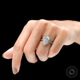 Angled lifestyle view of pear halo diamond ring on finger