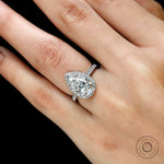 Pear cut lab grown diamond ring against black background