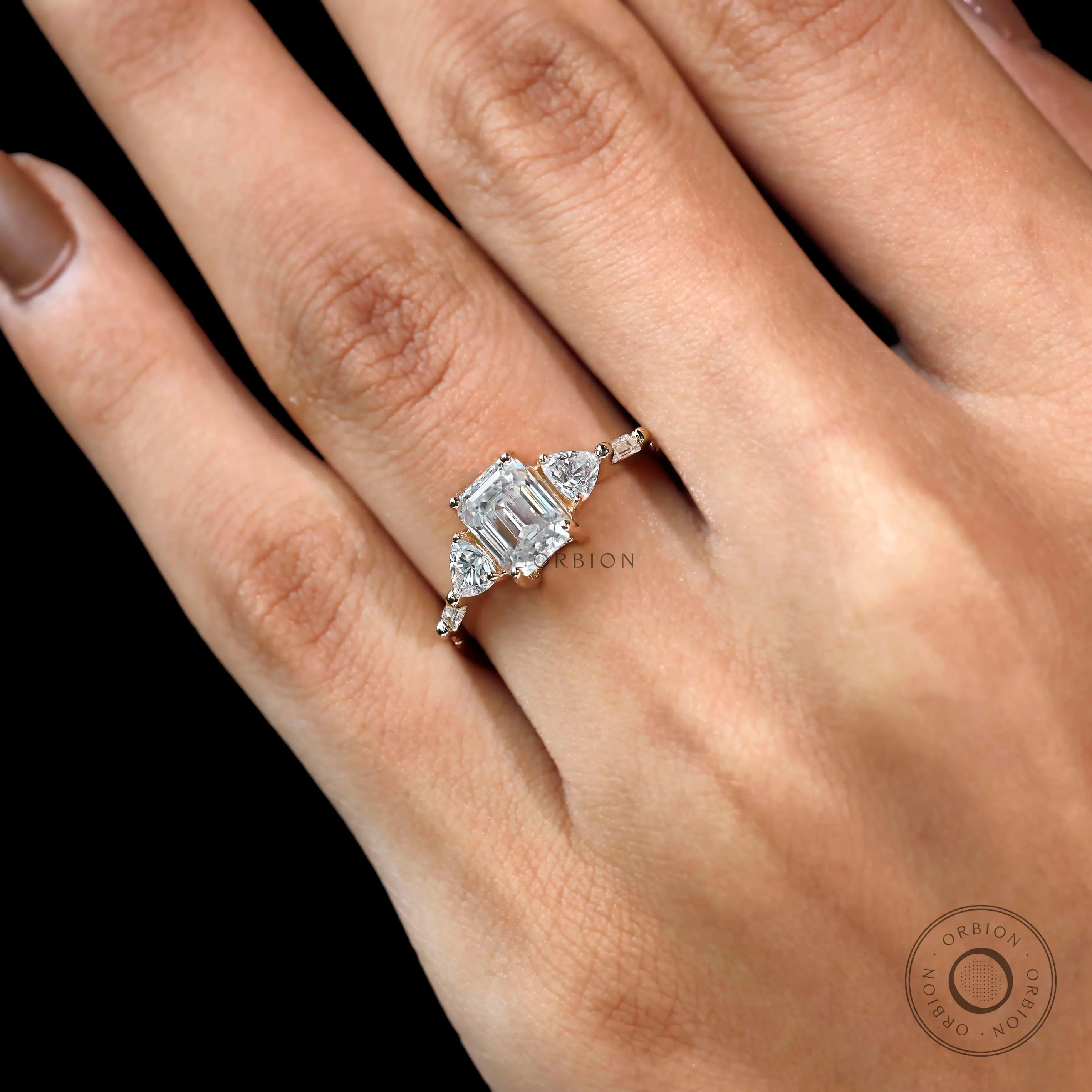 Close up of emerald cut moissanite with geometric side stones