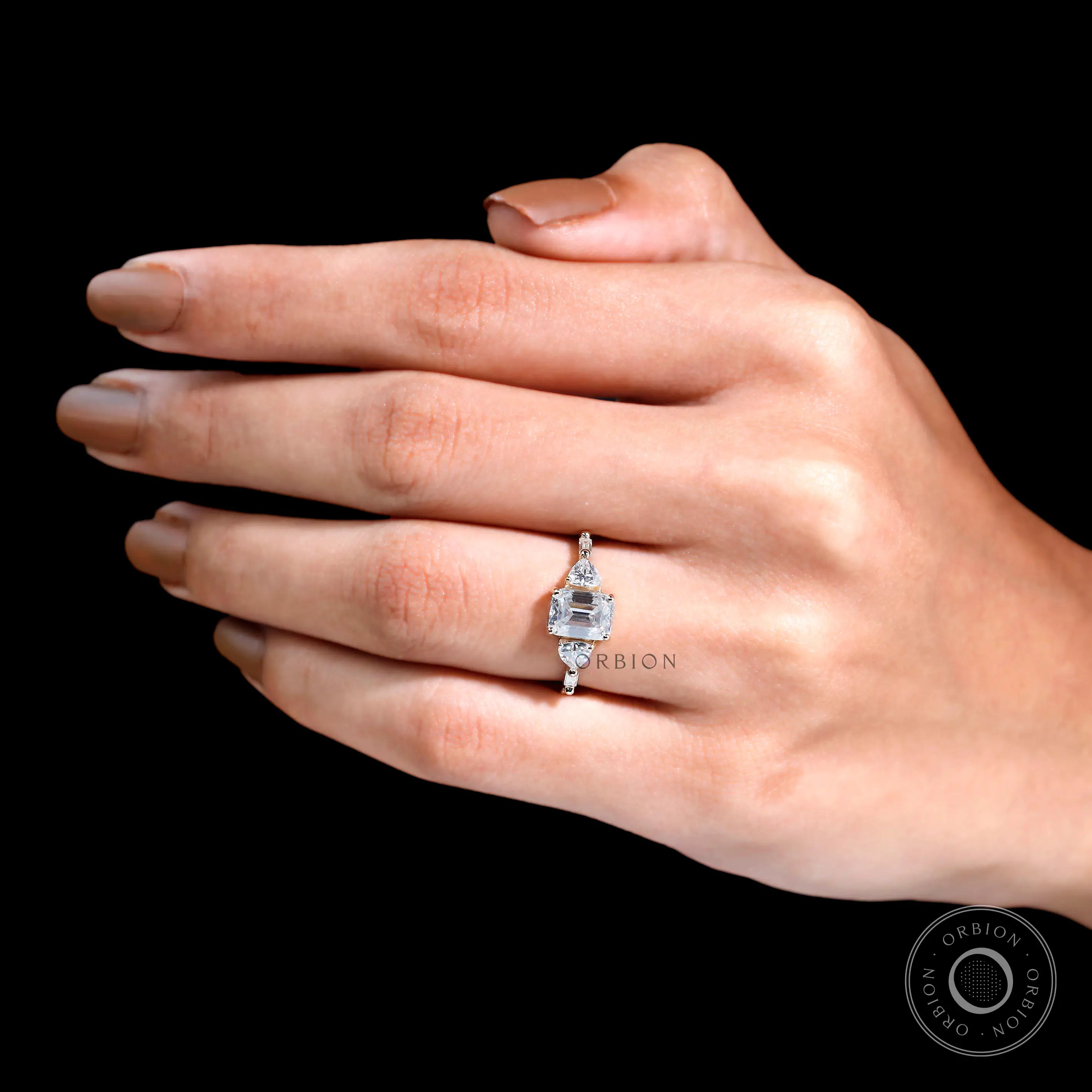 Step cut emerald engagement ring with brilliant accents