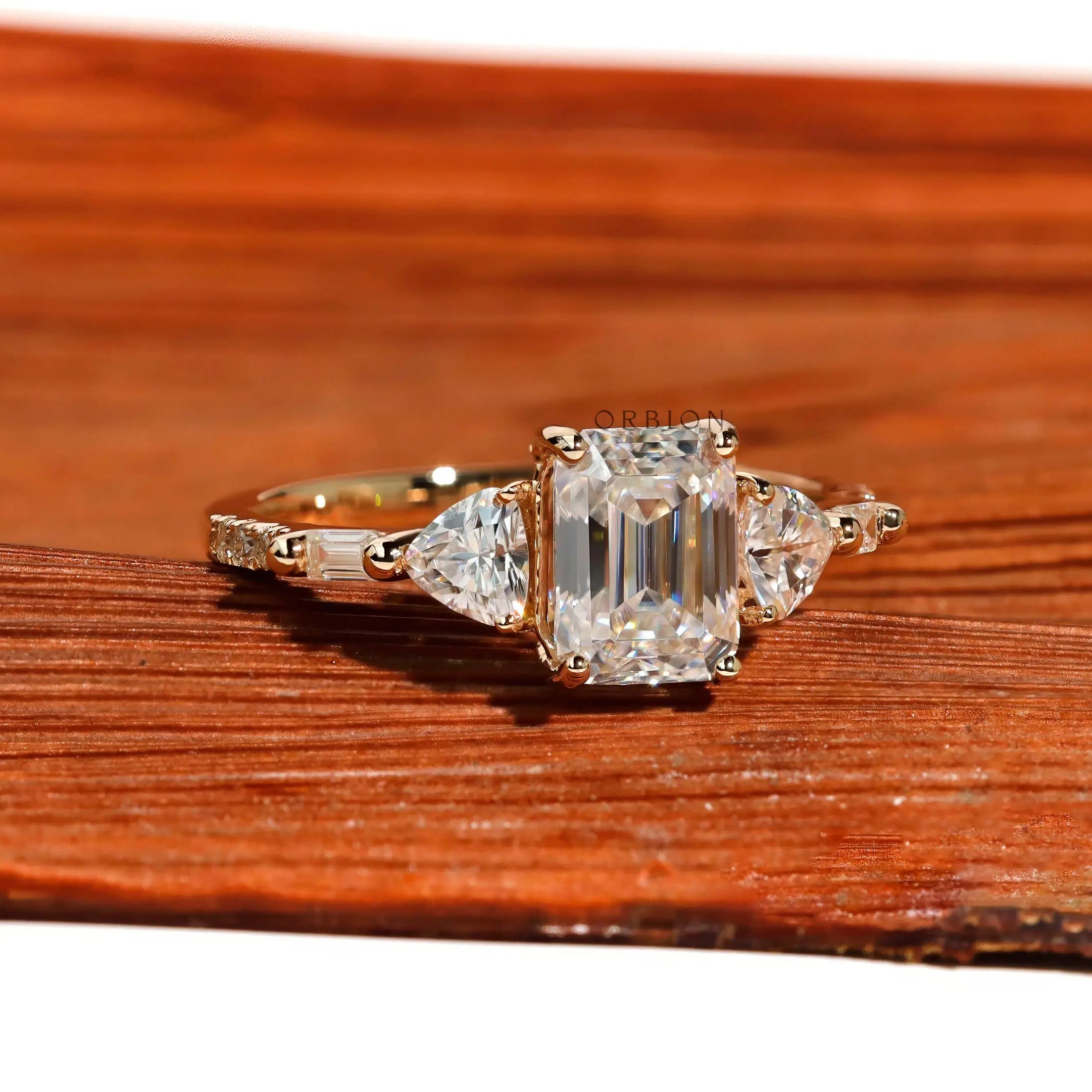 Emerald step cut engagement ring with trillion side stones