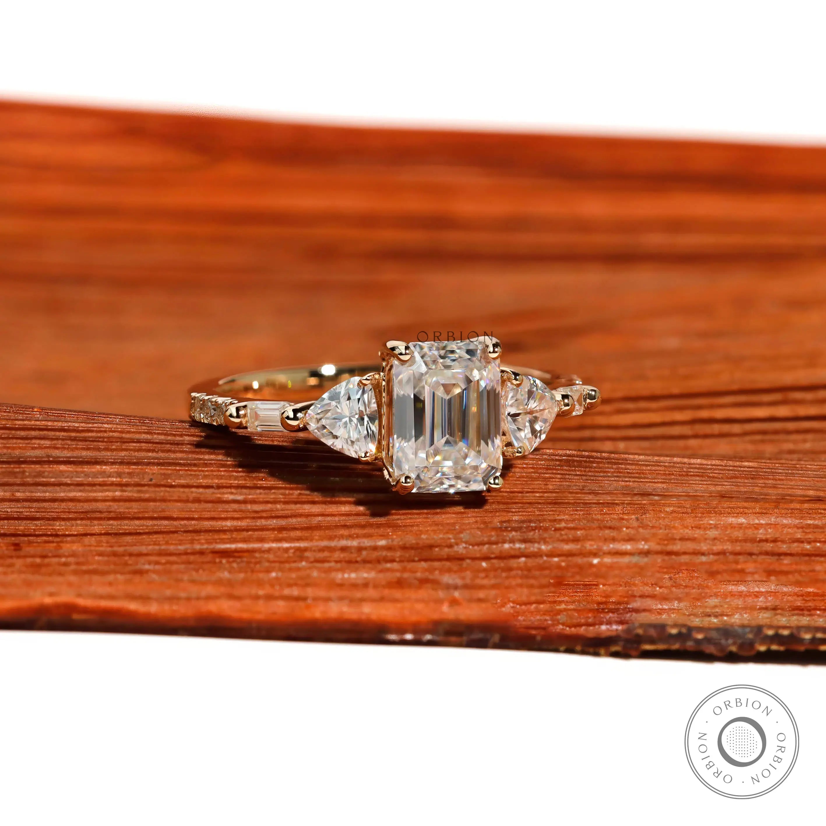 Emerald step cut engagement ring with trillion side stones