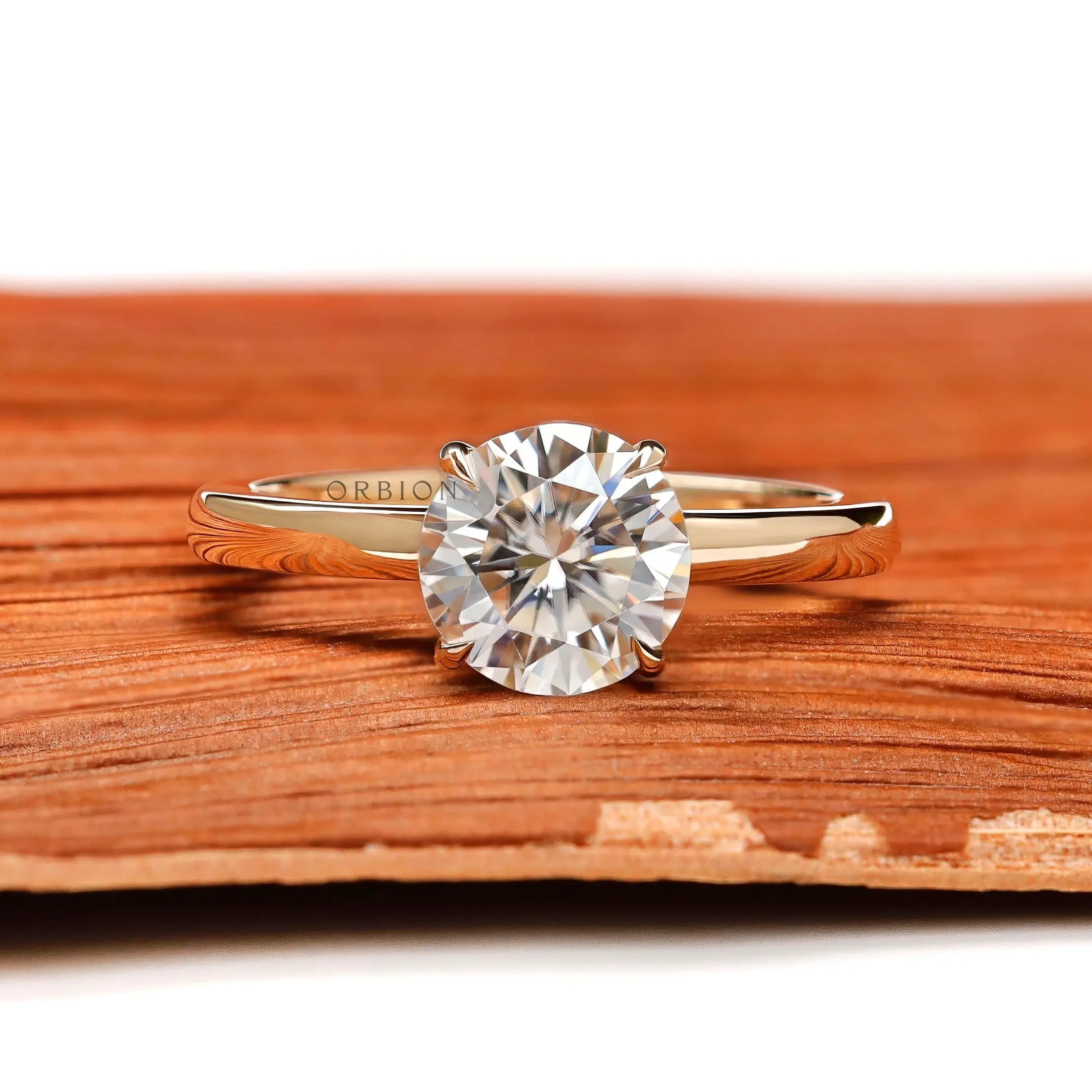 Round moissanite solitaire ring in yellow gold front view