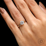 Close-up of round moissanite solitaire ring worn