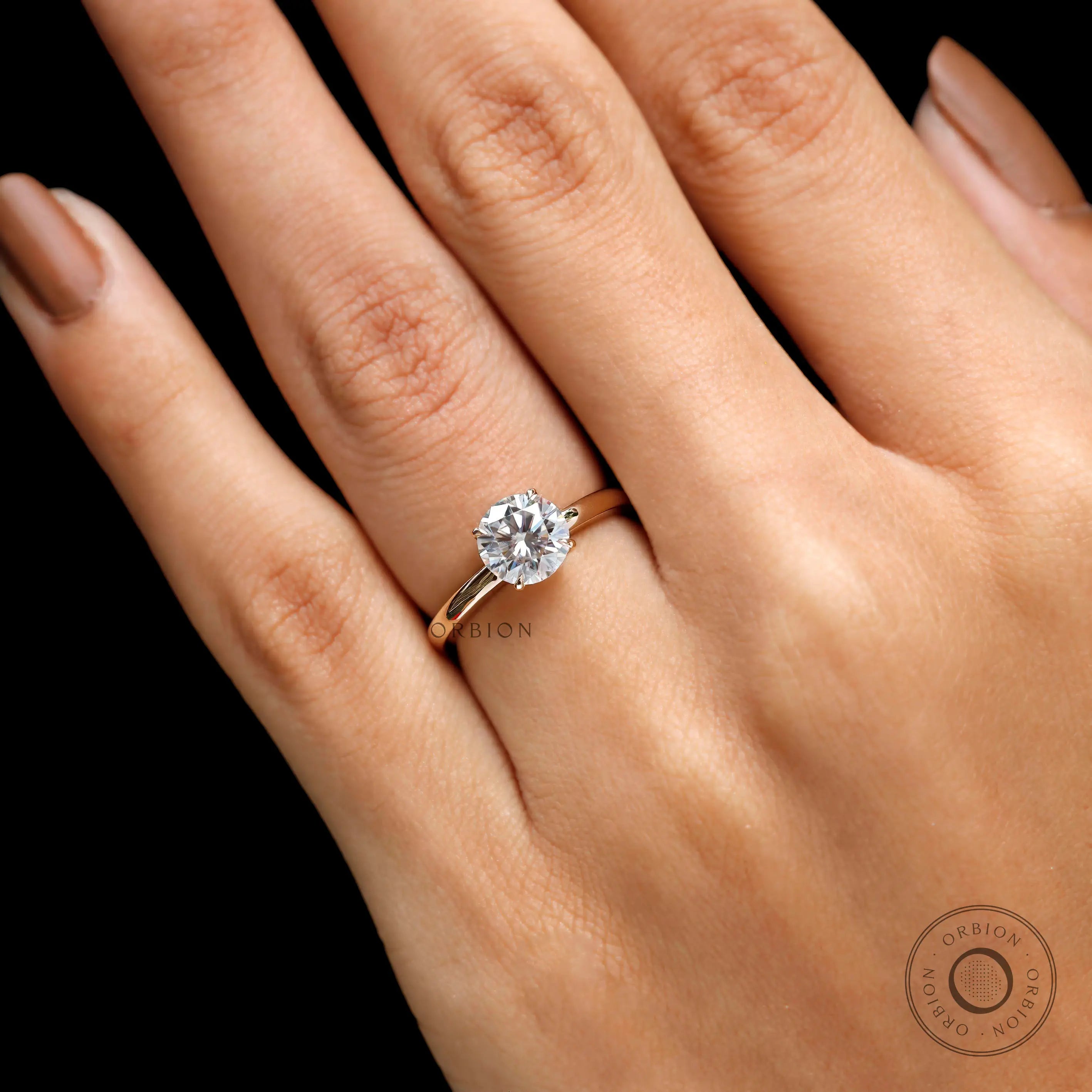 Close-up of round moissanite solitaire ring worn