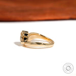 Side profile showing chunky gold band and pear moissanite