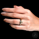 Close-up of bold gold band and pear-cut moissanite