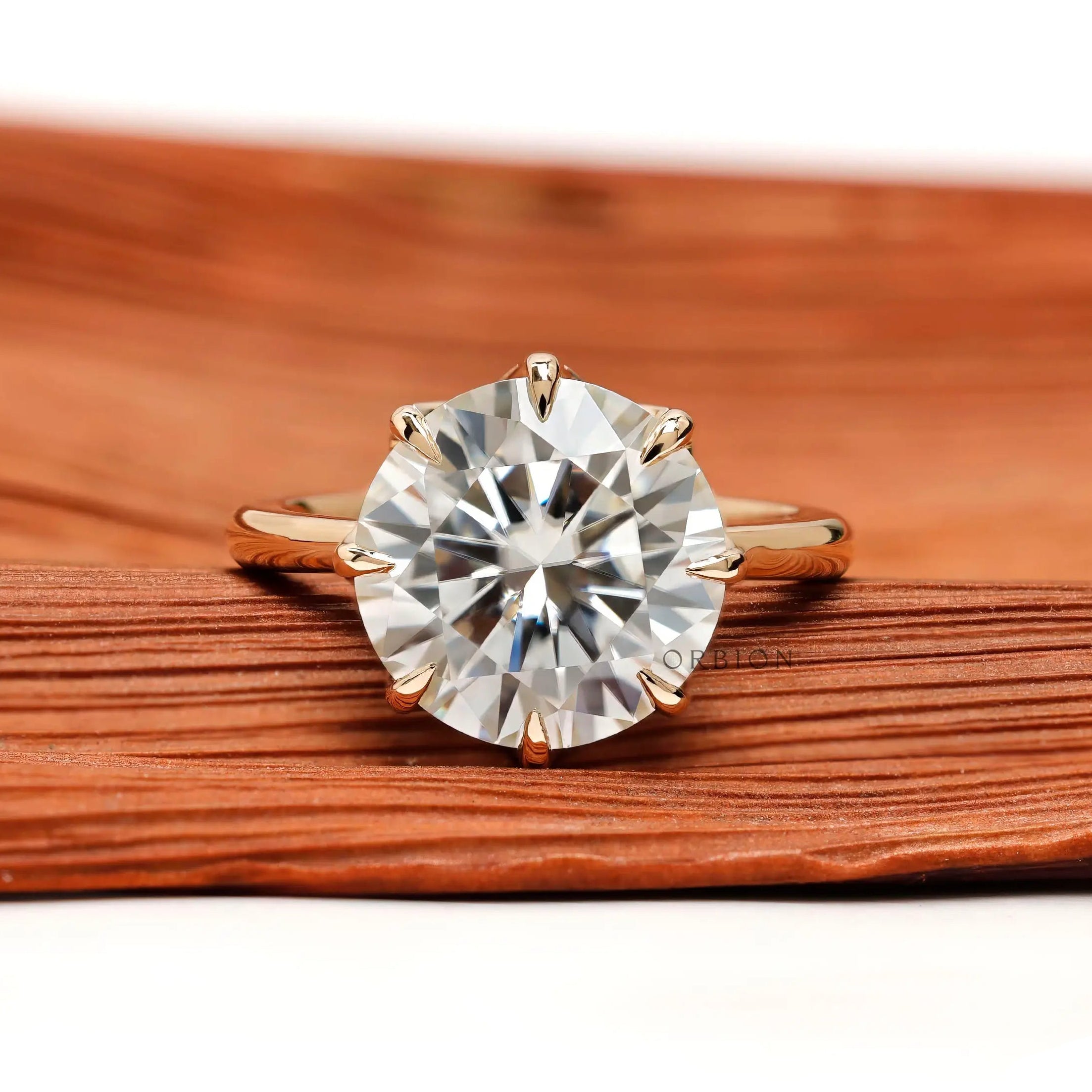 Front view 11 mm round solitaire with eight prongs in yellow gold.
