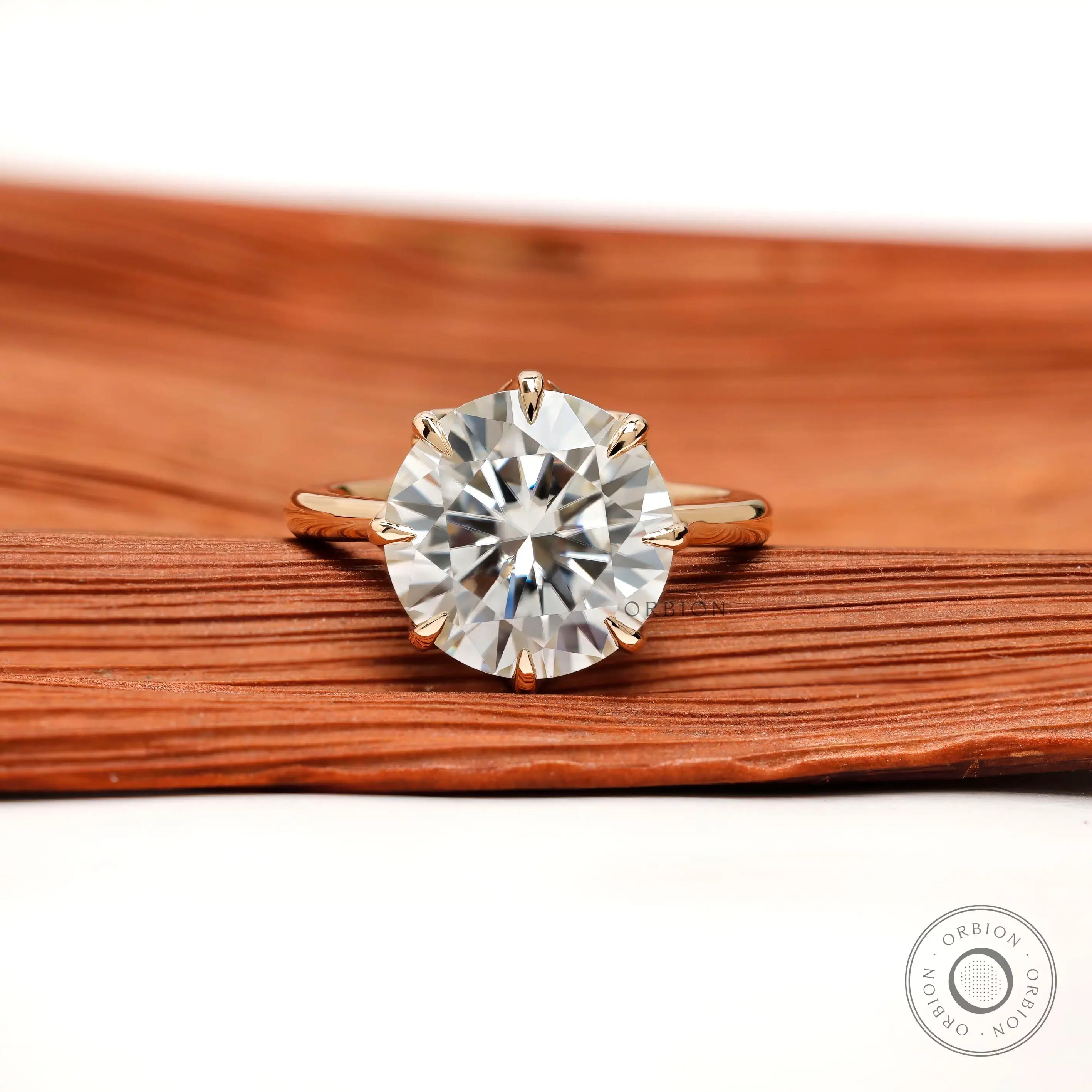 Front view 11 mm round solitaire with eight prongs in yellow gold.