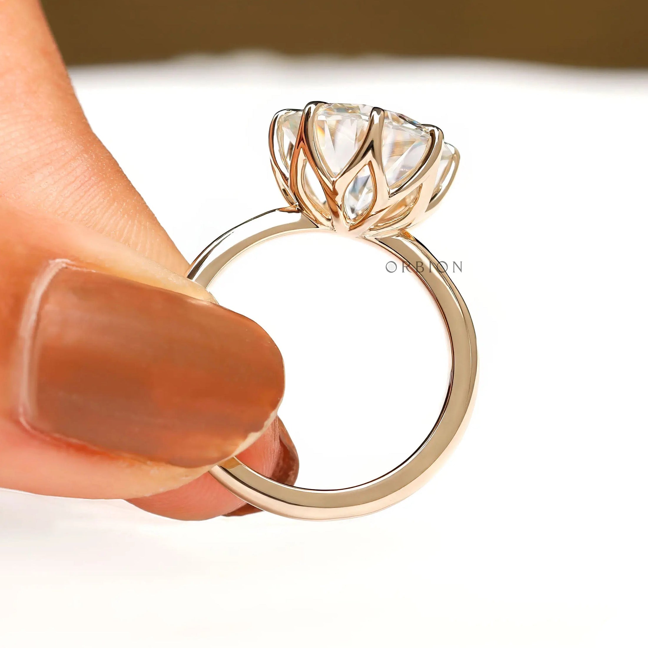 Close side detail of open tulip prongs supporting large round center stone.