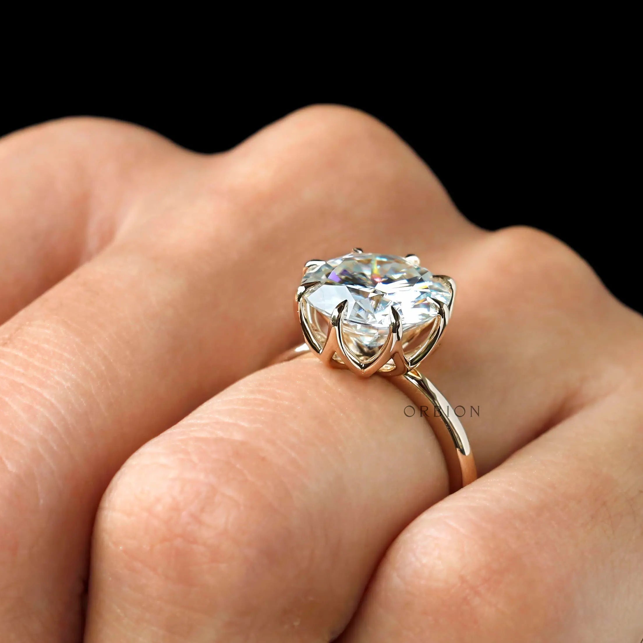 Top view on hand showing bold round solitaire finger coverage.