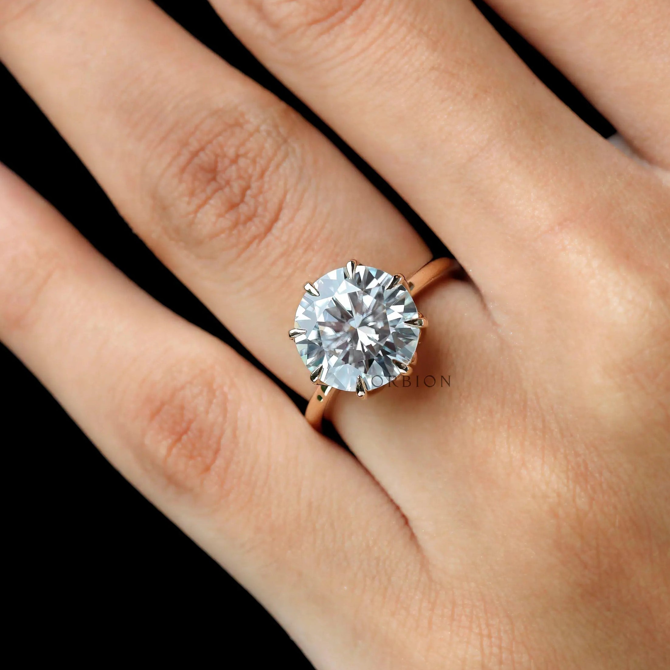 Close-up hand view highlighting brilliance of 11 mm round stone.