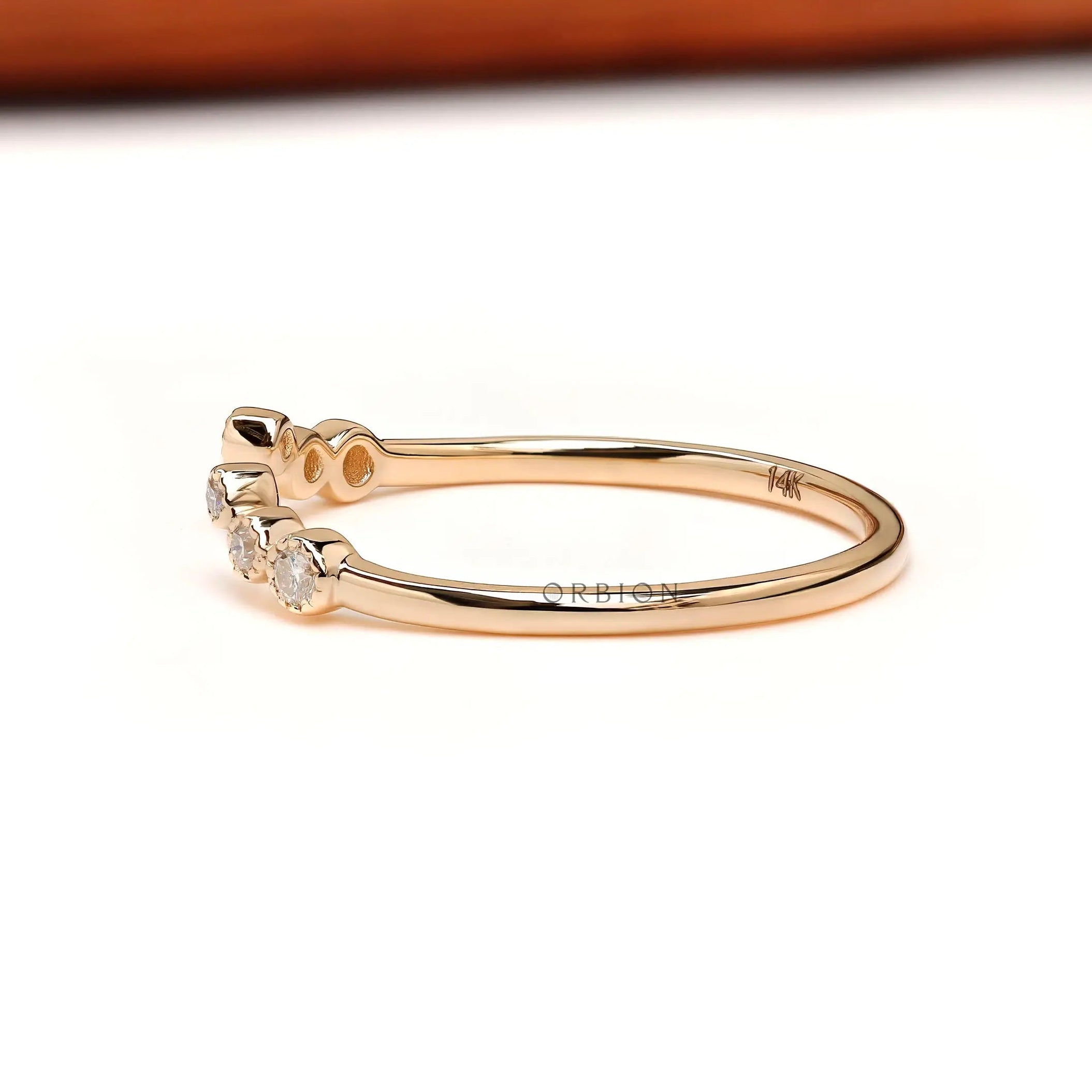Curved open wedding band side view, slim yellow gold shank with round diamonds