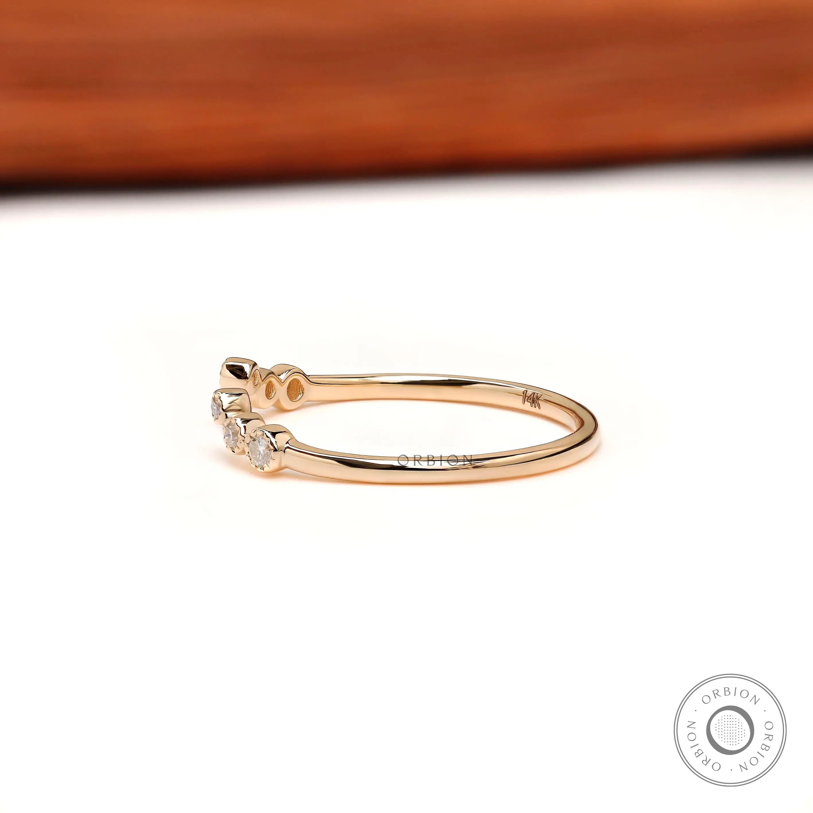 Curved open wedding band side view, slim yellow gold shank with round diamonds