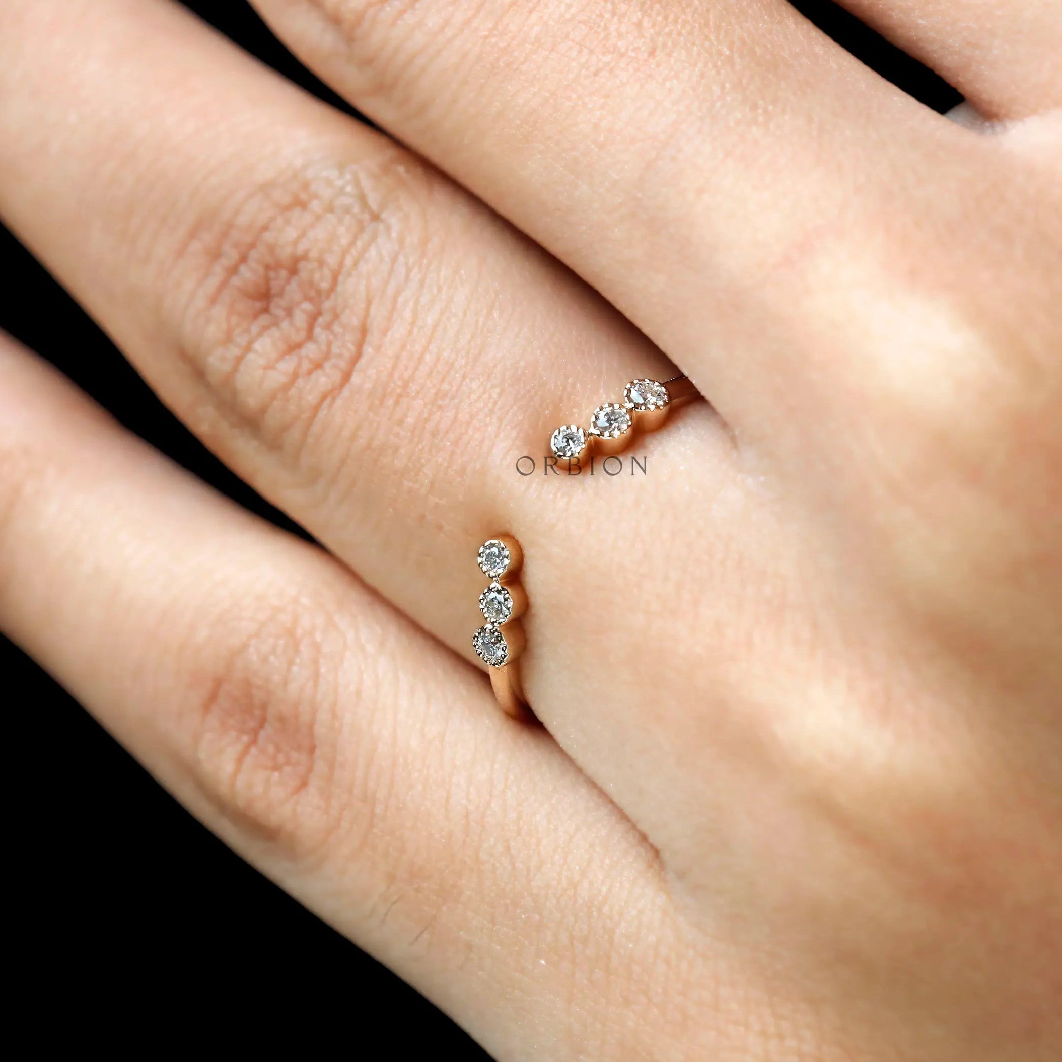 Open curved yellow gold diamond ring styled on hand, stacking inspiration