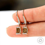 Statement dangling earrings with emerald cut moissanite and round diamonds