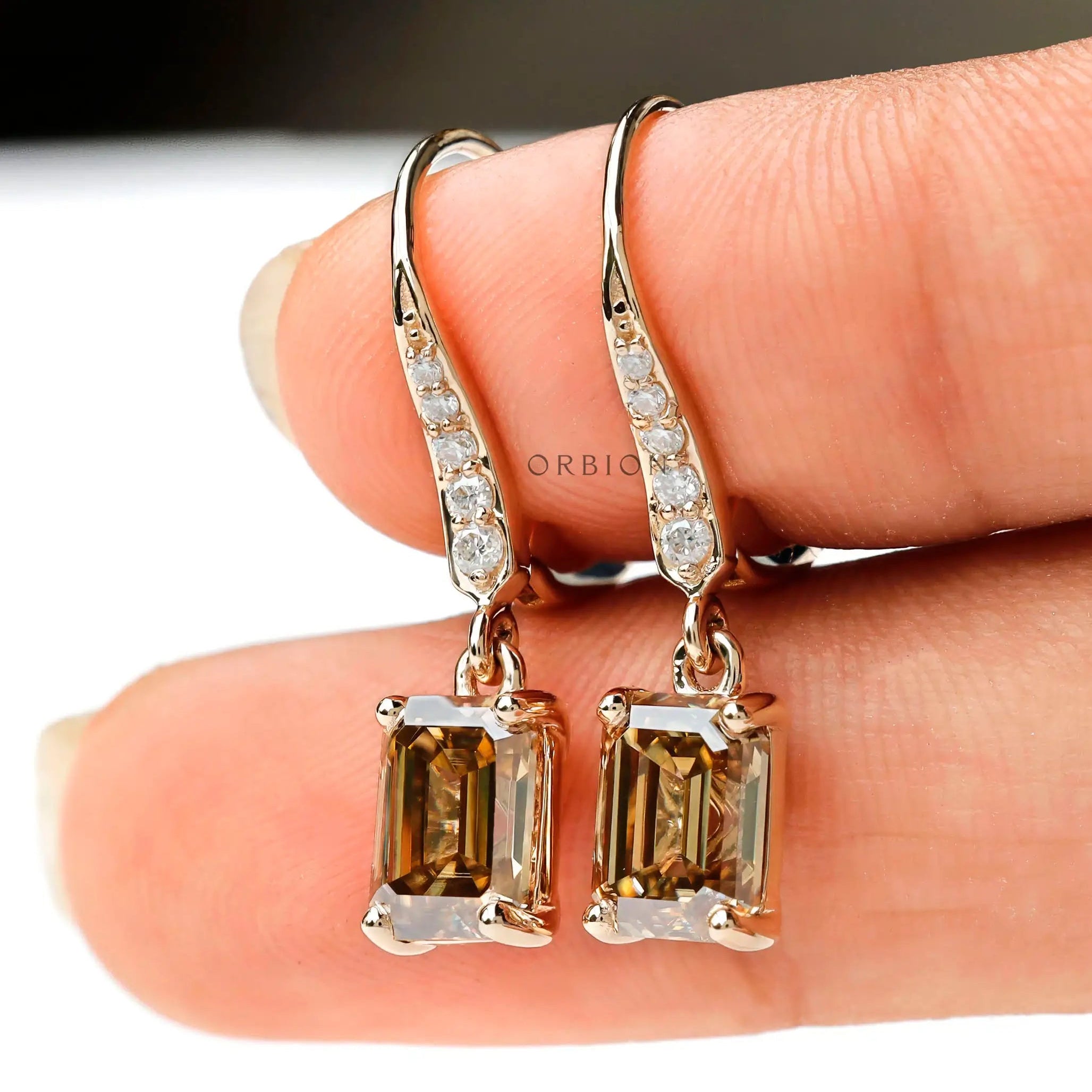 Statement dangling earrings with emerald cut moissanite and round diamonds