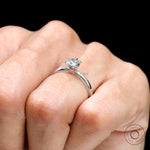 Six prong set round diamond solitaire engagement ring on finger