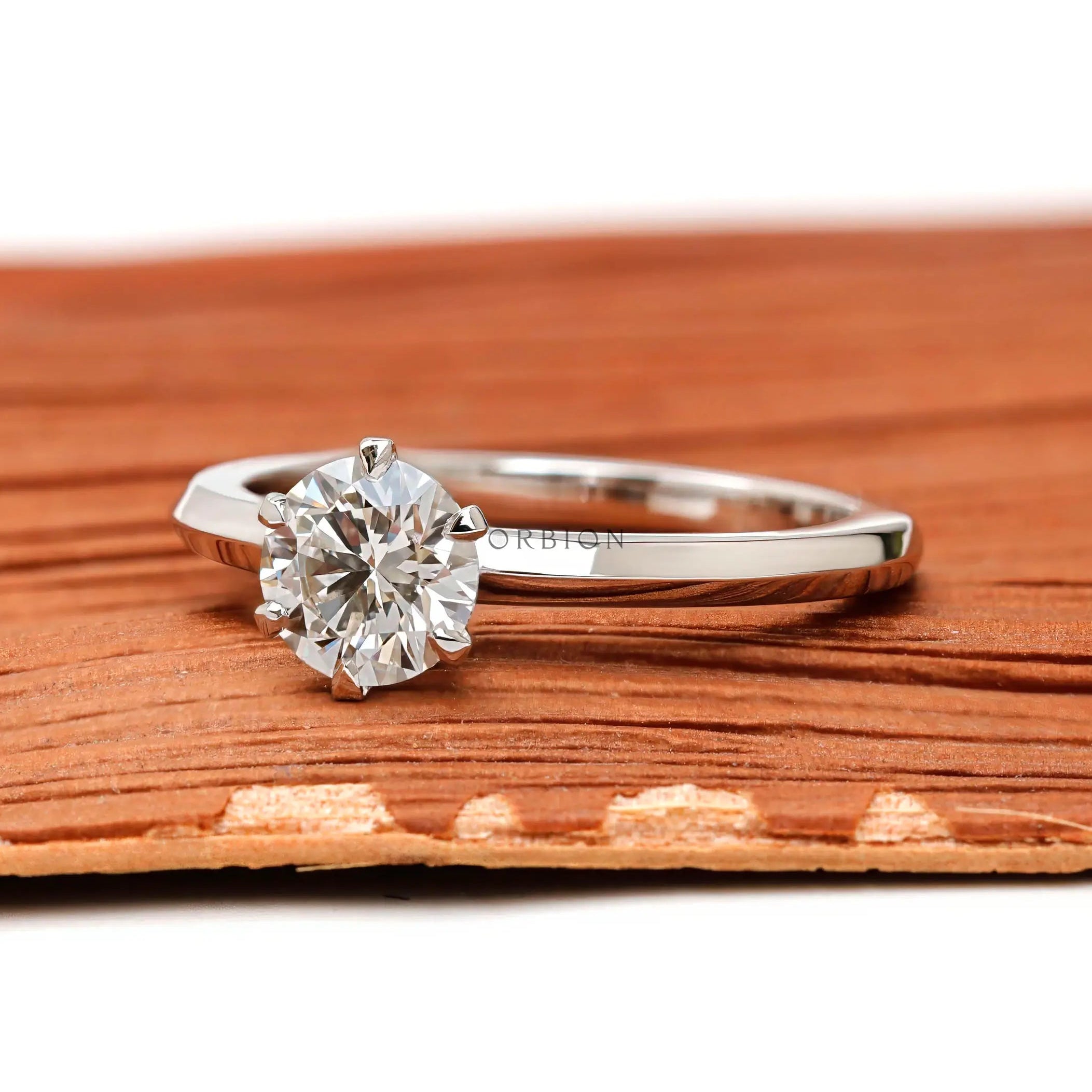 Side profile of round lab diamond engagement ring showing prong setting