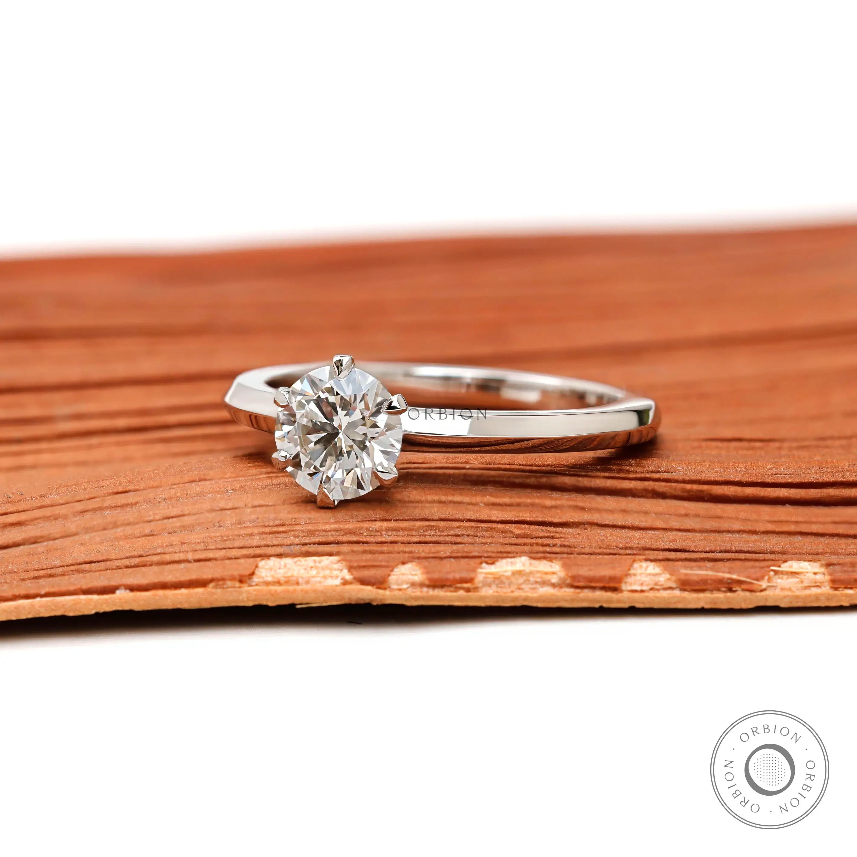 Side profile of round lab diamond engagement ring showing prong setting
