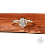 Oval lab diamond bezel ring front view on wood
