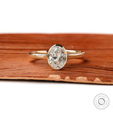 Oval lab diamond bezel ring front view on wood