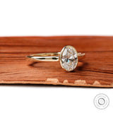 Angled view of oval bezel lab diamond yellow gold ring
