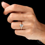 Oval bezel lab diamond ring worn on hand black background