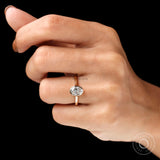 Oval bezel lab diamond ring worn on hand black background