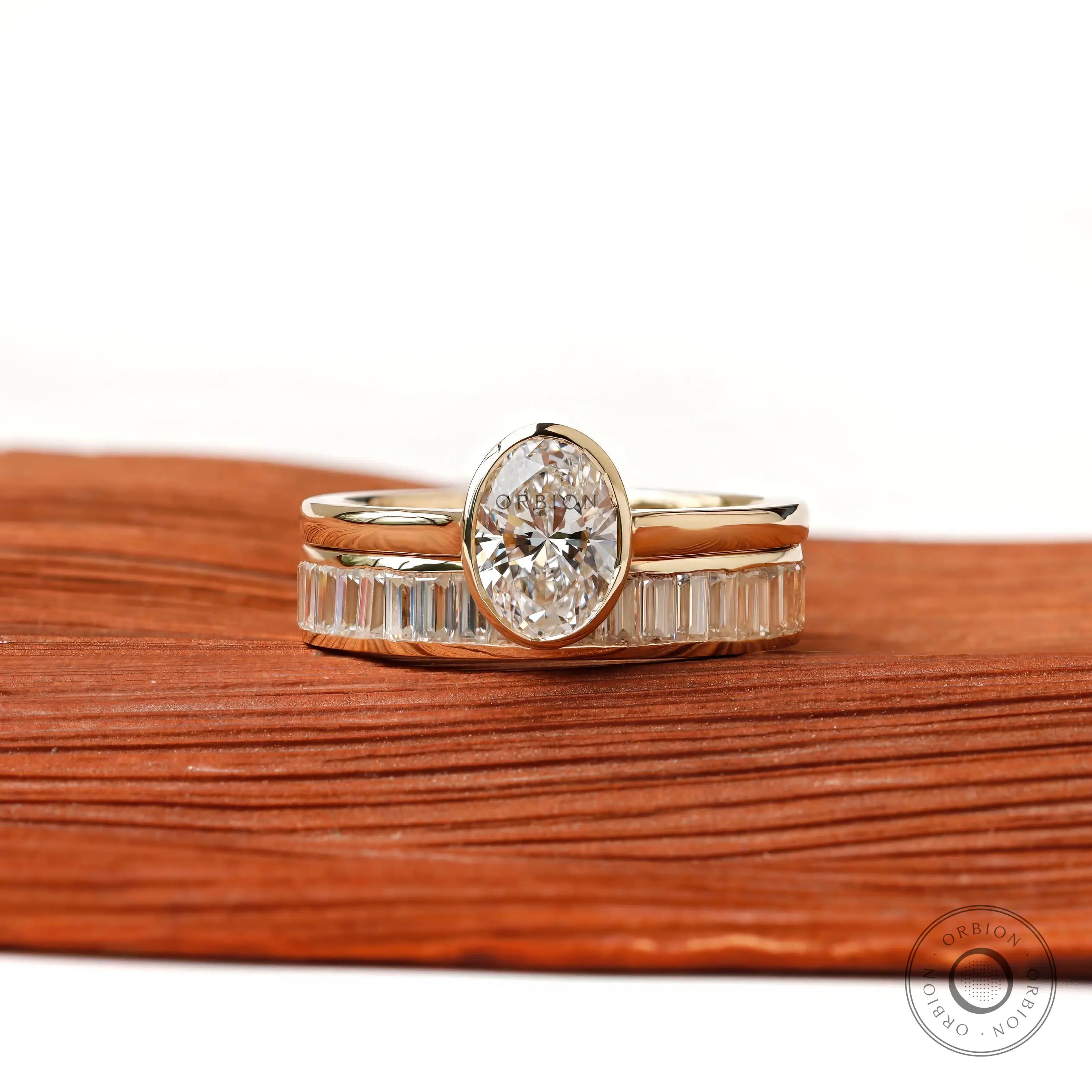 Front view of oval solitaire ring set with baguette band