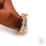 Side close-up of oval solitaire ring set held by hand